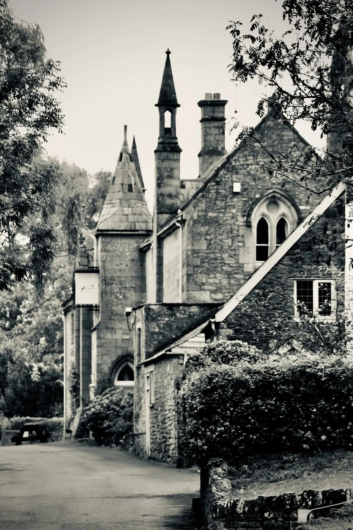 The Hostelrie in Goodrich, a Gothic-style stone building with a spire, chimney and pointed-arch windows.